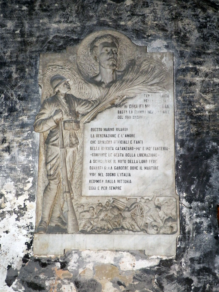 figura di soldato che omaggia Oberdan con la Vittoria, allegoria della battaglia (lapide commemorativa ai caduti, opera isolata) di Guidetti Dante (attribuito) (primo quarto XX)