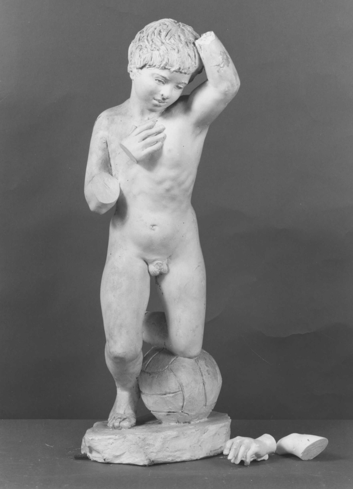 bambino che gioca a football (scultura) di Berti Antonio (secondo quarto sec. XX)