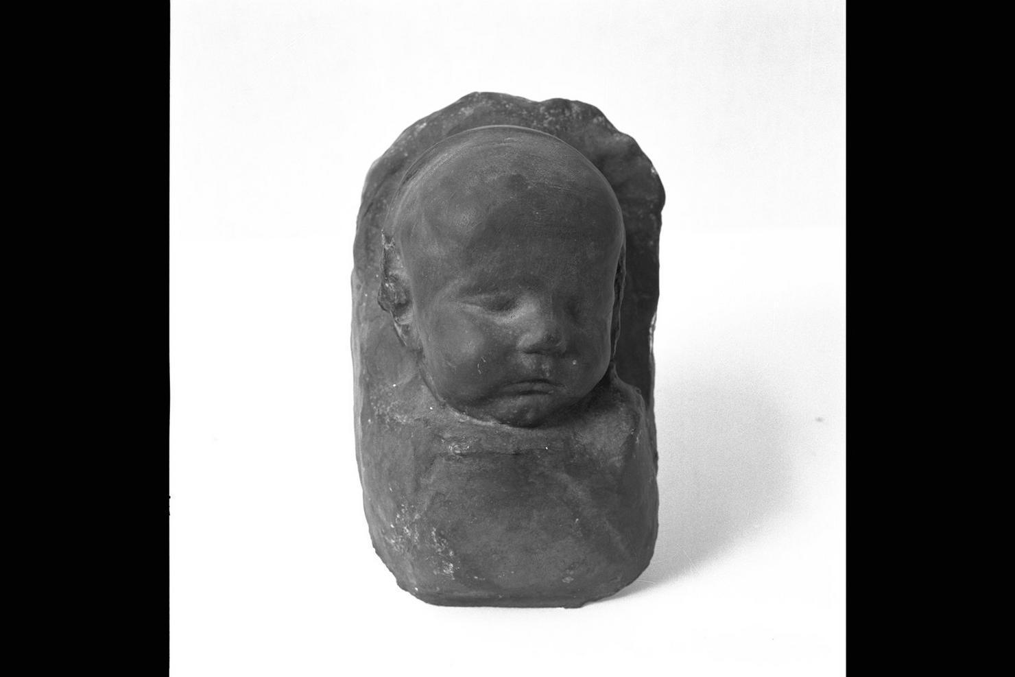 testa di infante (rilievo) di De Angelis Giuseppe (sec. XX)