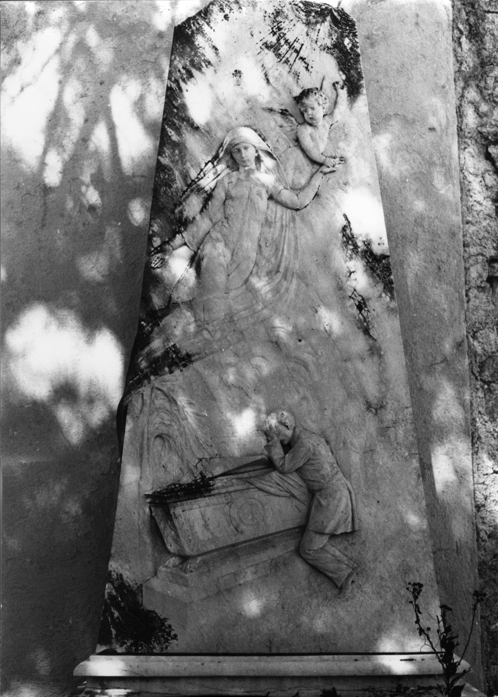 Il marito piange sulla bara della defunta la cui anima è condotta in cielo da un angelo (monumento funebre)