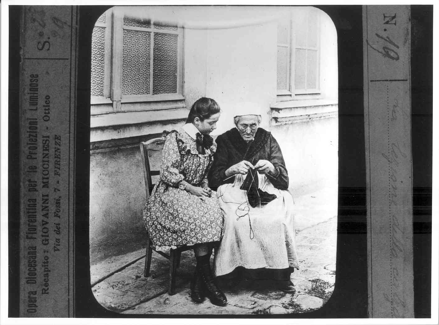 Donna anziana che fa la calza sotto lo sguardo di una bambina (diapositiva) di Anonimo (XX)