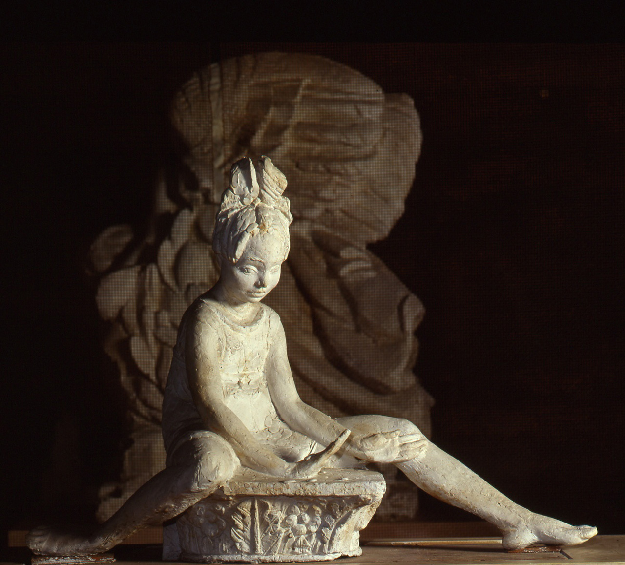 Bambina che gioca a sassetto, bambina seduta che gioca (statua) di Andreotti Libero (sec. XX)