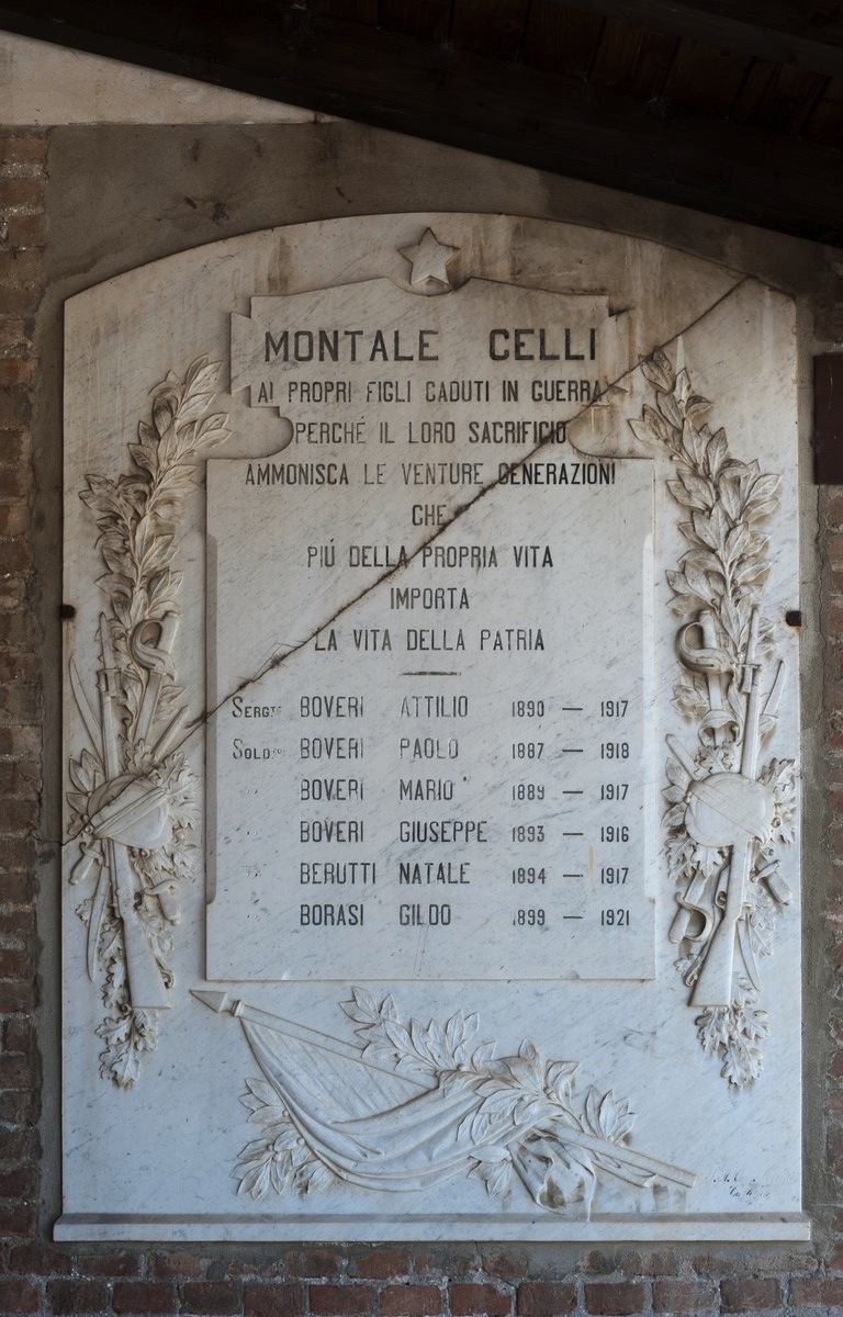 tropaion con elmo e rami di quercia e alloro, bandiera (lapide commemorativa ai caduti) di Ferretti, A (primo quarto sec. XX)