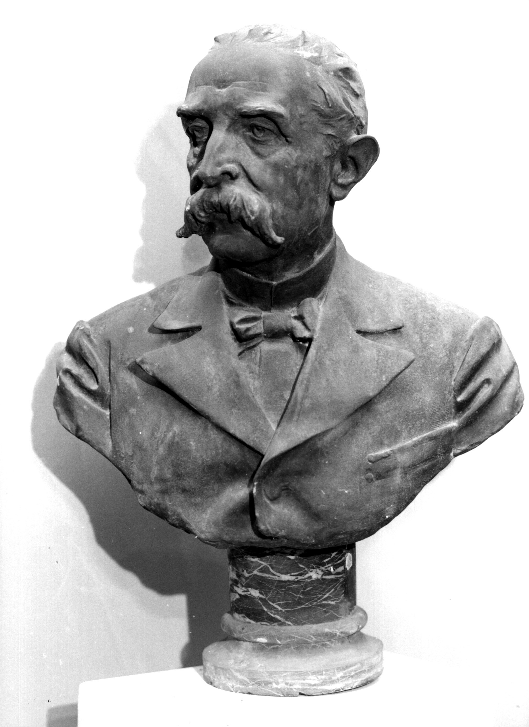 Arrigo Forti, busto maschile con baffi in giù, giacca e cravatta a farfalla (scultura, opera isolata) di Spazzi Carlo (sec. XX)
