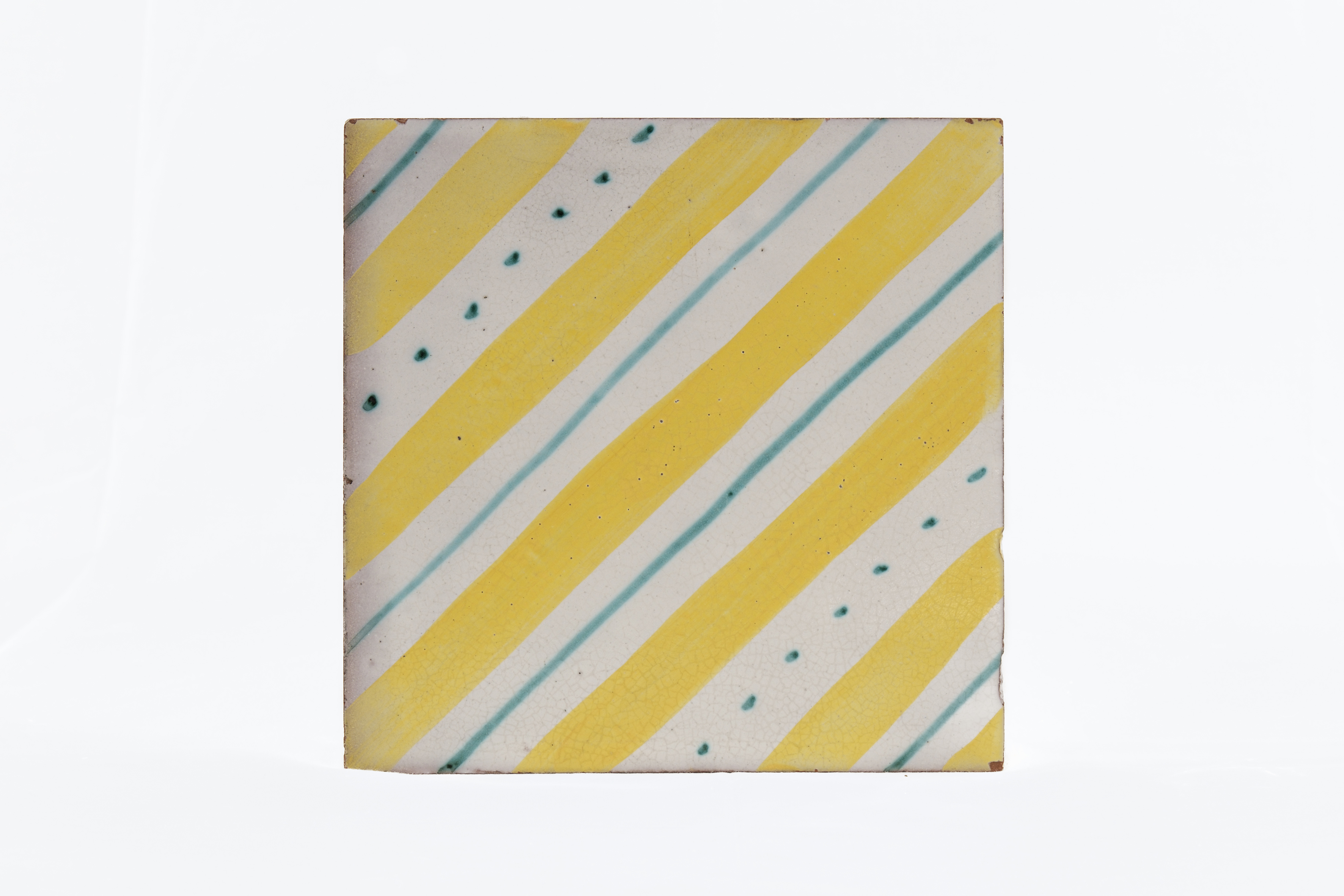 Fasce diagonali in giallo, quattro filetti in verde e due file di sette puntini, in diagonale (piastrella) di Gambone, Guido (officina) - ambito vietrese, produzione fiorentina (anni cinquanta XX)