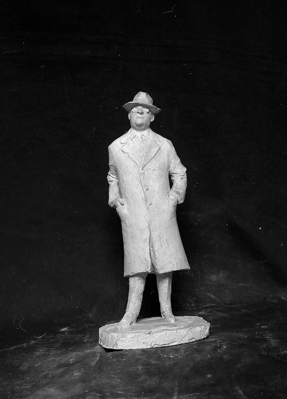 Uomo con cappotto e cappello (scultura, elemento d'insieme) di Griselli Italo Orlando (sec. XX)