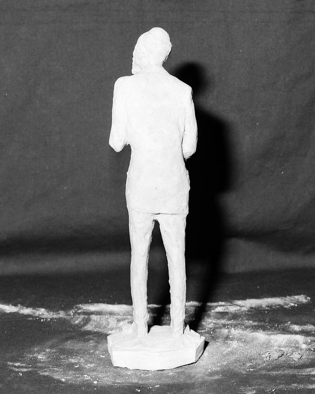 Uomo in doppiopetto (scultura, elemento d'insieme) di Griselli Italo Orlando (sec. XX)